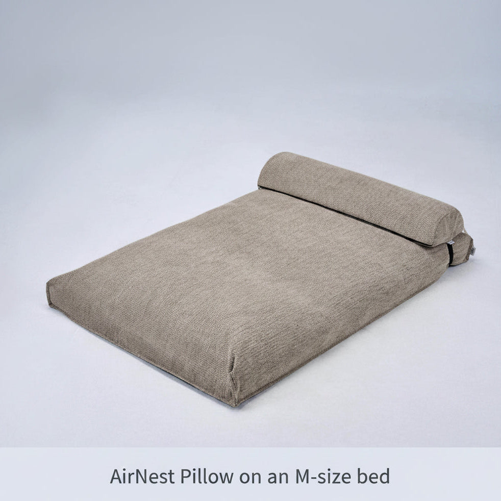 AirNest pillow with anthracite-gray cushion and folded top panel, loop handle on side