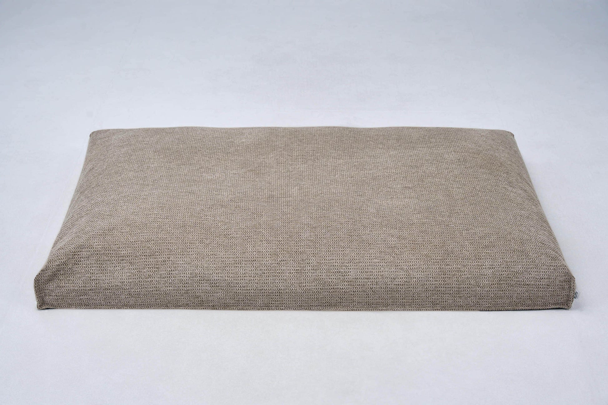 Dog bed cushion in light beige with centered seam and folded edge