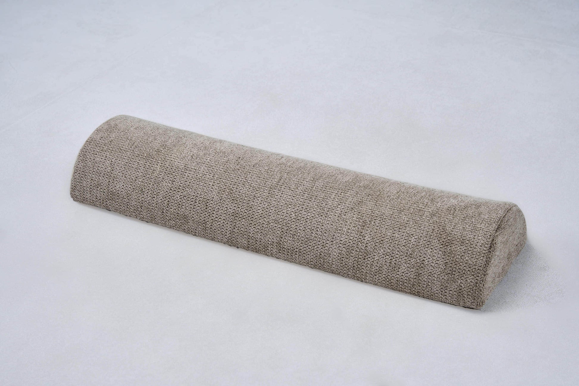 AirNest pillow in textured anthracite-gray fabric, rolled bolster shape